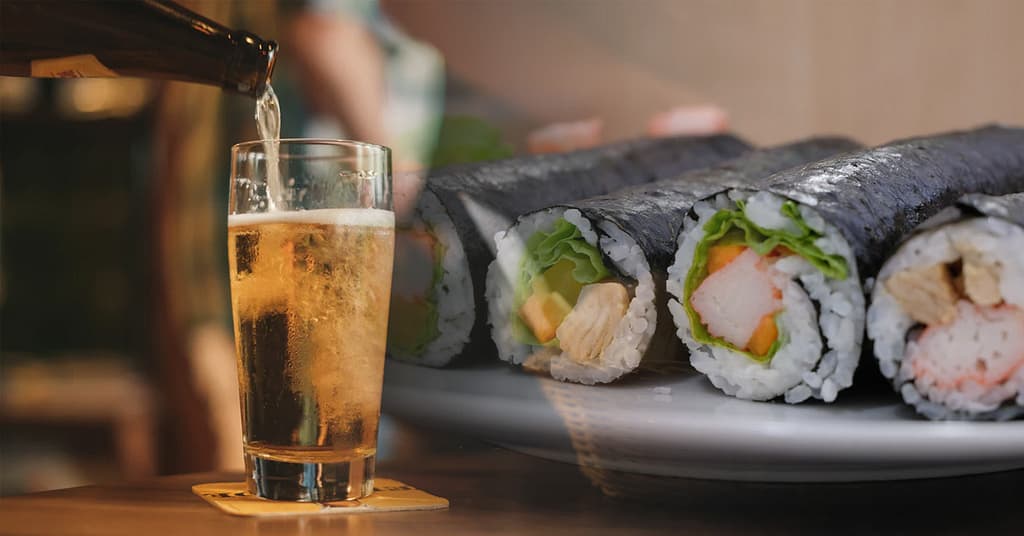 Verre de bière avec des sushis sur une assiette