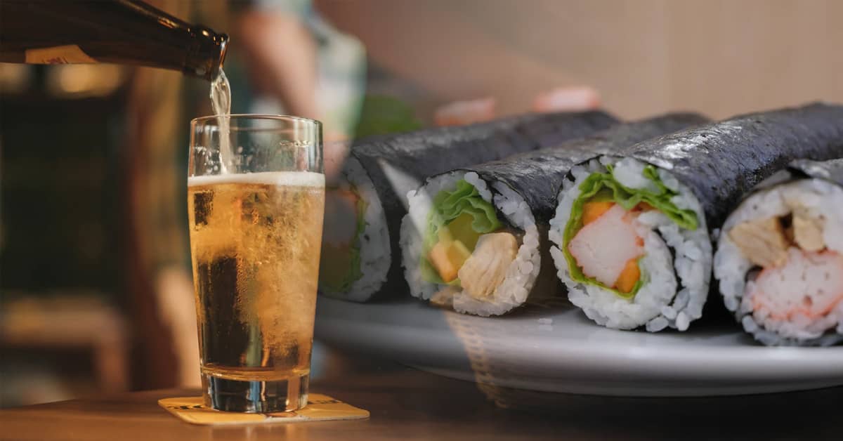 Bicchiere di birra con sushi su un piatto