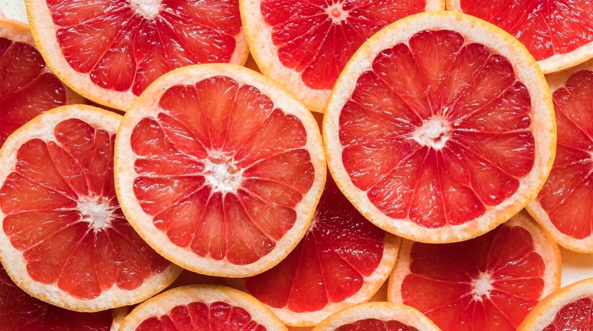 Primer plano de rodajas de pomelo rojo jugosas, frescas y brillantes.