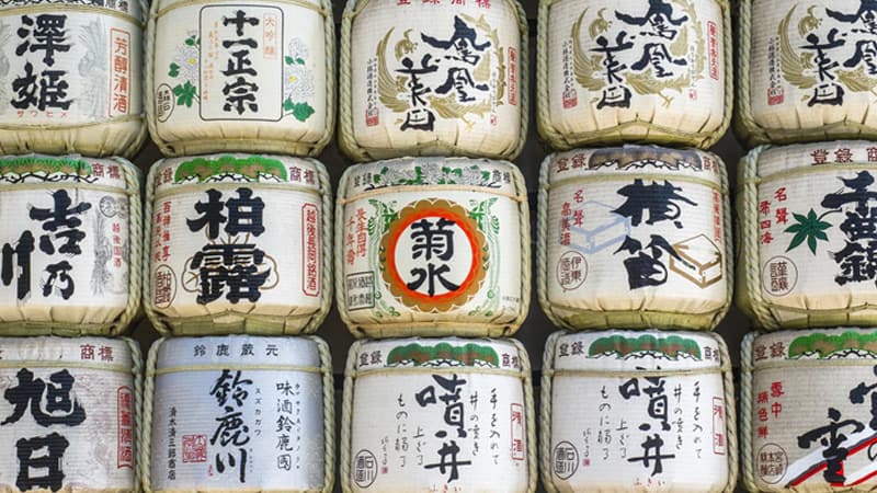Traditional Japanese sake barrels with calligraphy characters