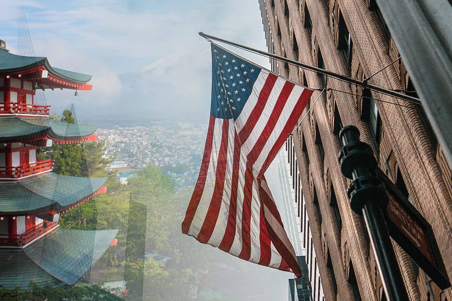 Japanese pagoda with American flag and urban architecture in the background, overprint.